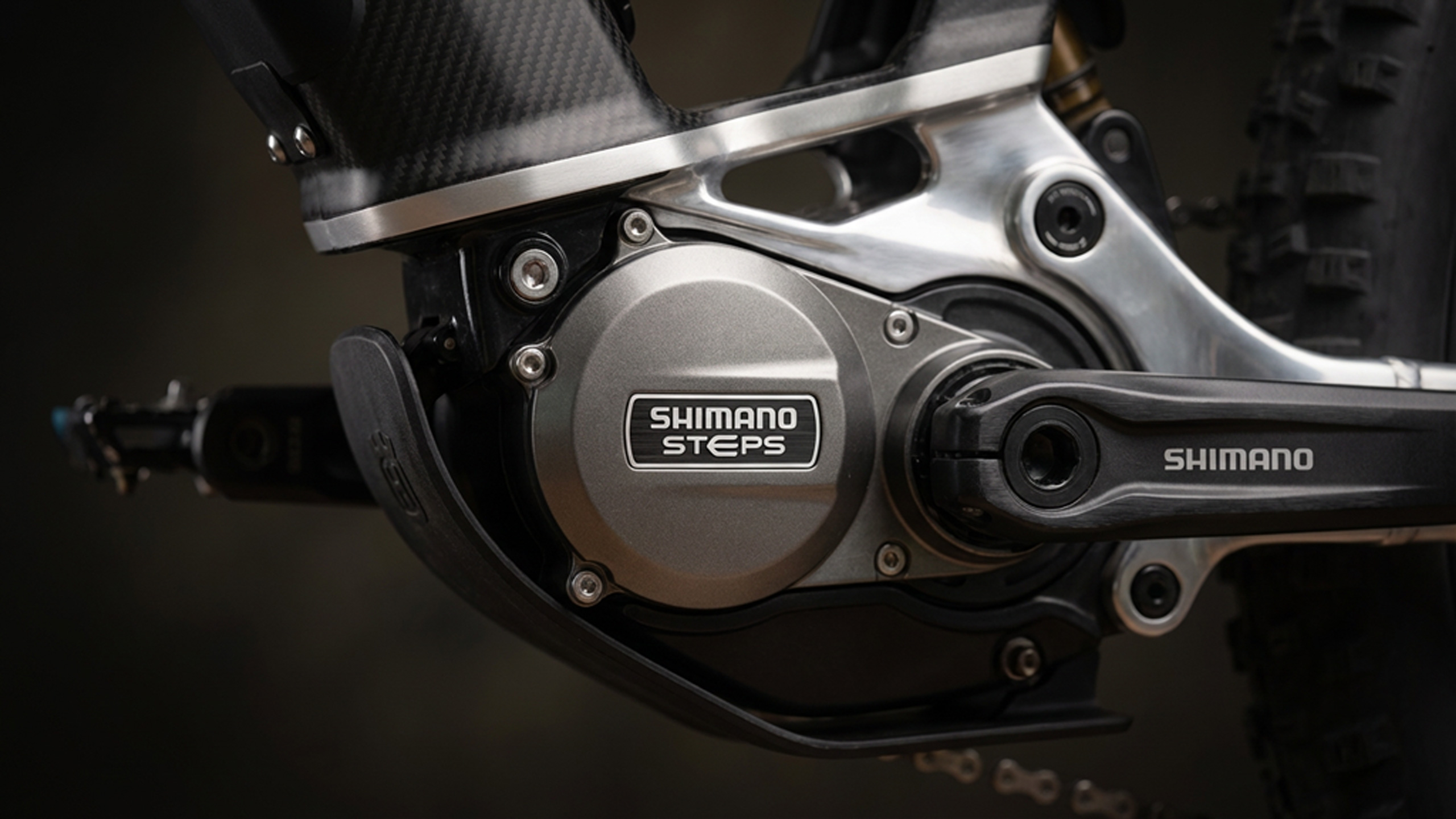 Zbliżenie na jednostkę napędową Shimano STEPs (silnik środkowy) przy ramie roweru, widoczna okolica tabliczki znamionowej lub oznaczenia modelu (np. DU-EP600, EP801).